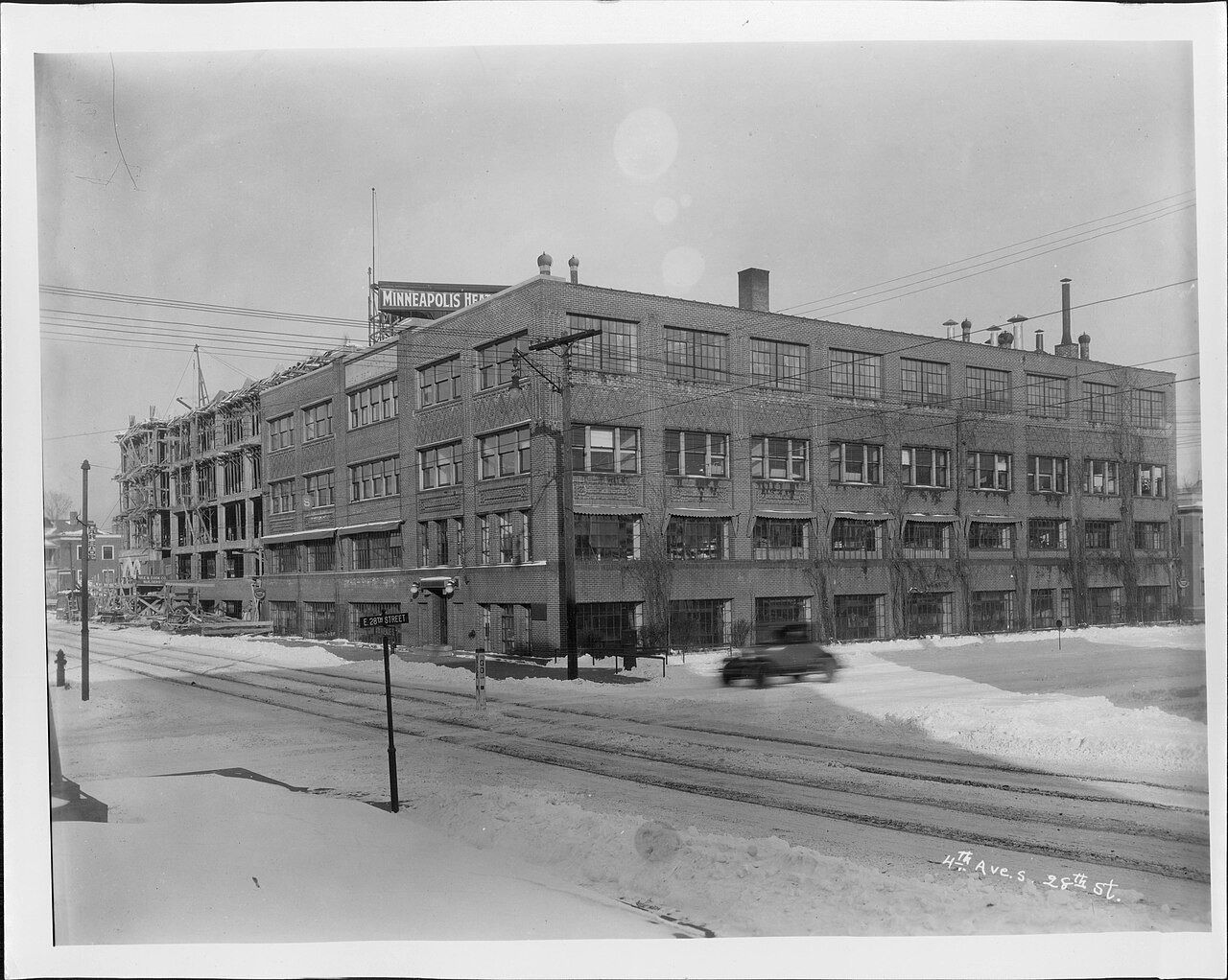 Black-and-white photo of a factory building on a snowy street