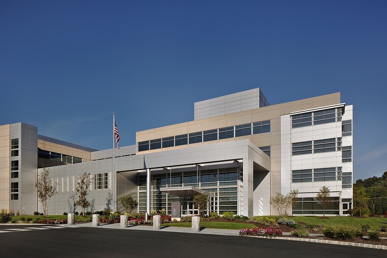 Low white office building with flags