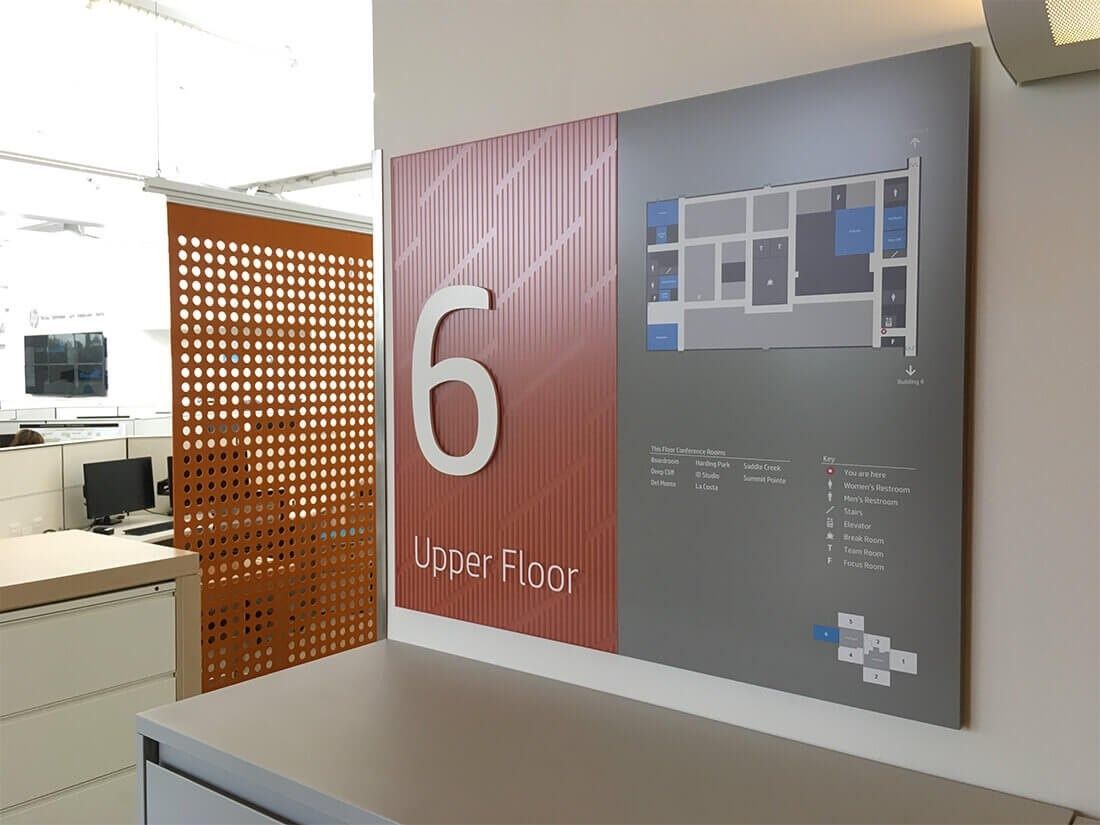 HP Inc.: A floor sign beside a perforated orange screen