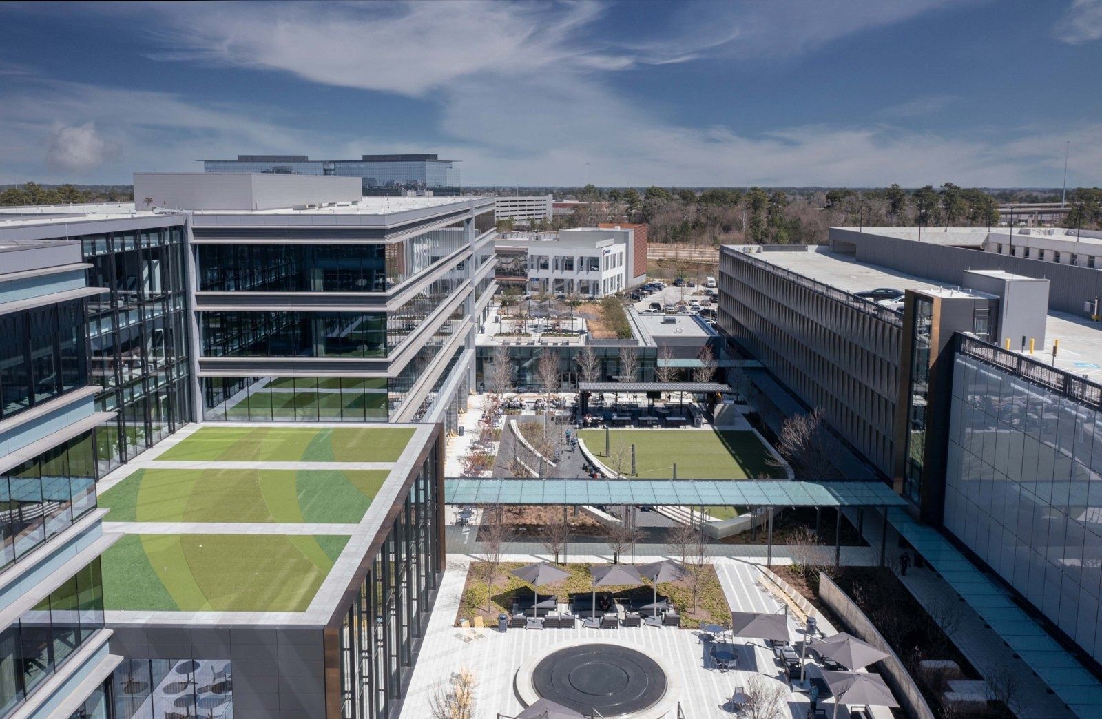 Hewlett Packard Enterprise: Aerial view of the campus with glass bridges crossing between buildings above a landscaped courtyard