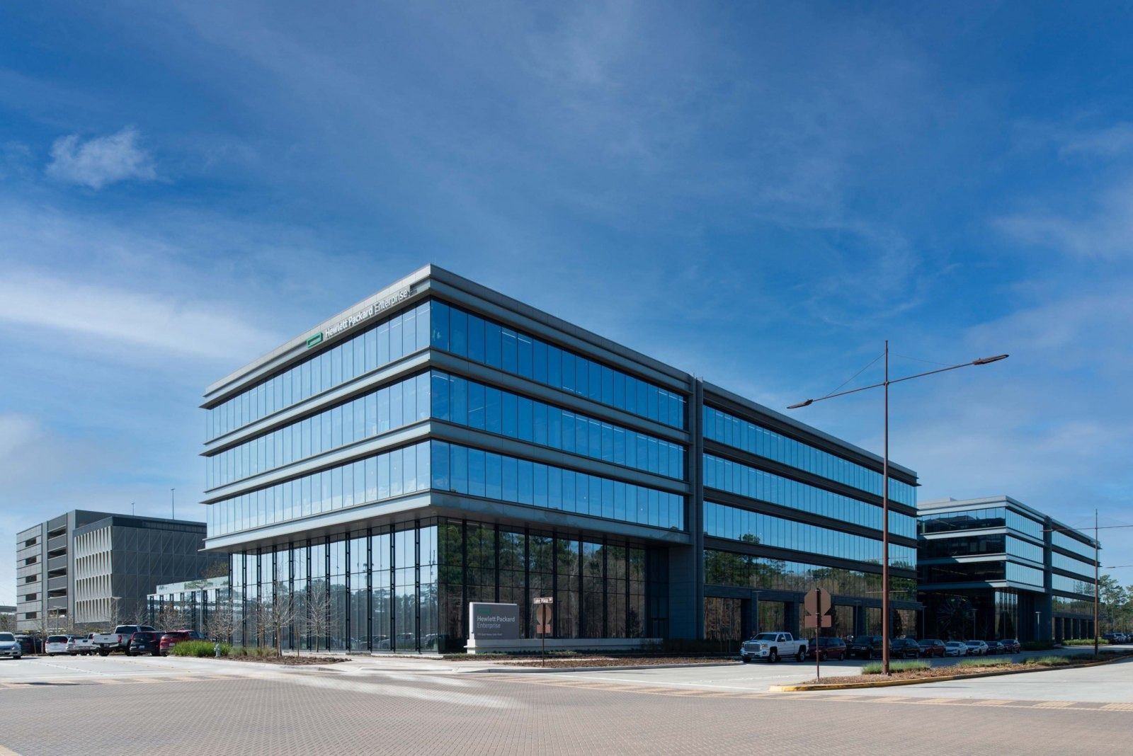 Hewlett Packard Enterprise: Five-story glass office building on a clear day, viewed from a corner