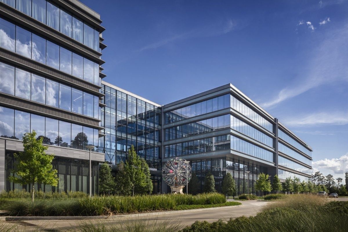 Hewlett Packard Enterprise: Glass office buildings with a sculpture and planted grounds in the foreground