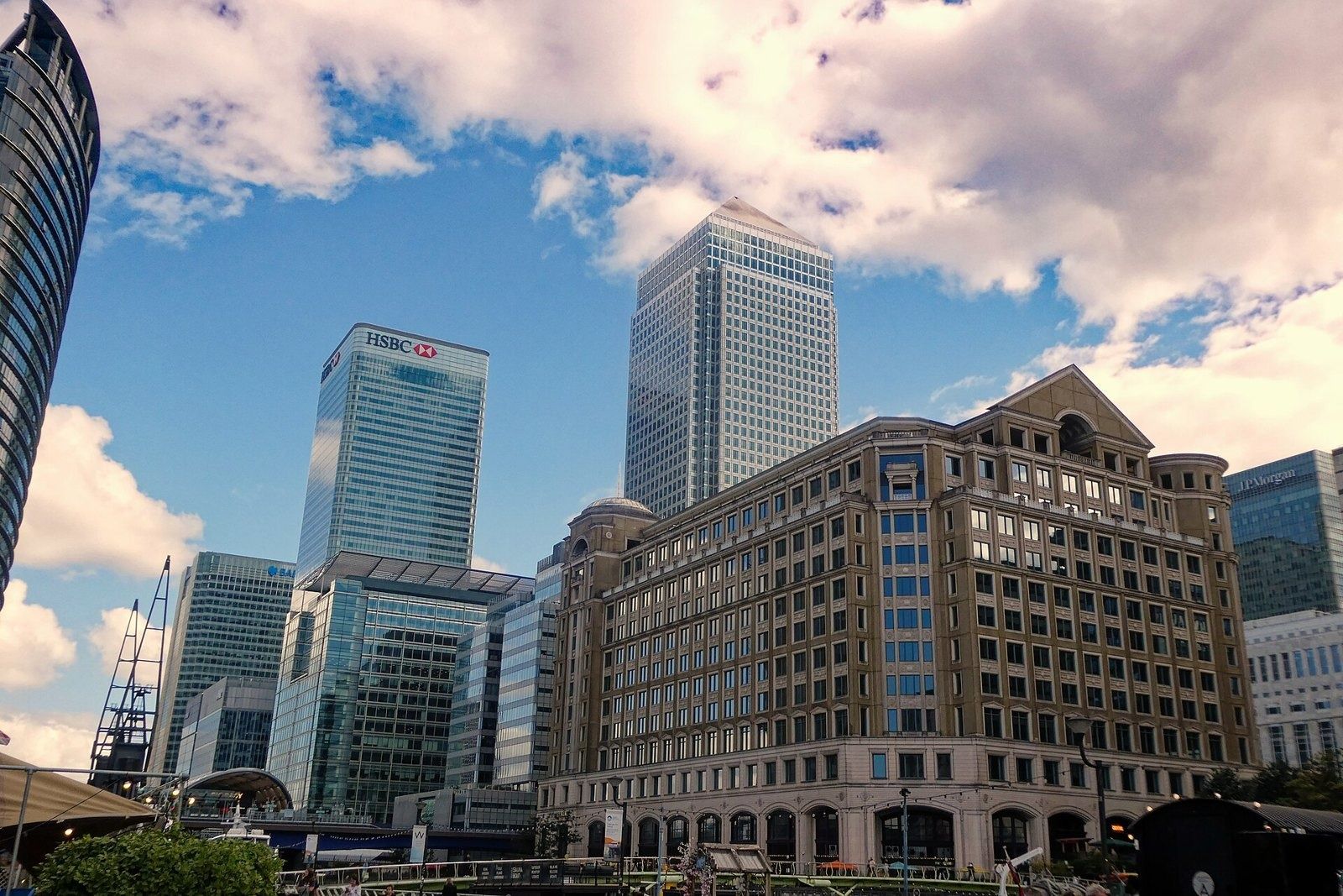 HSBC: Canary Wharf towers and a stone office block beside the West India Quay promenade