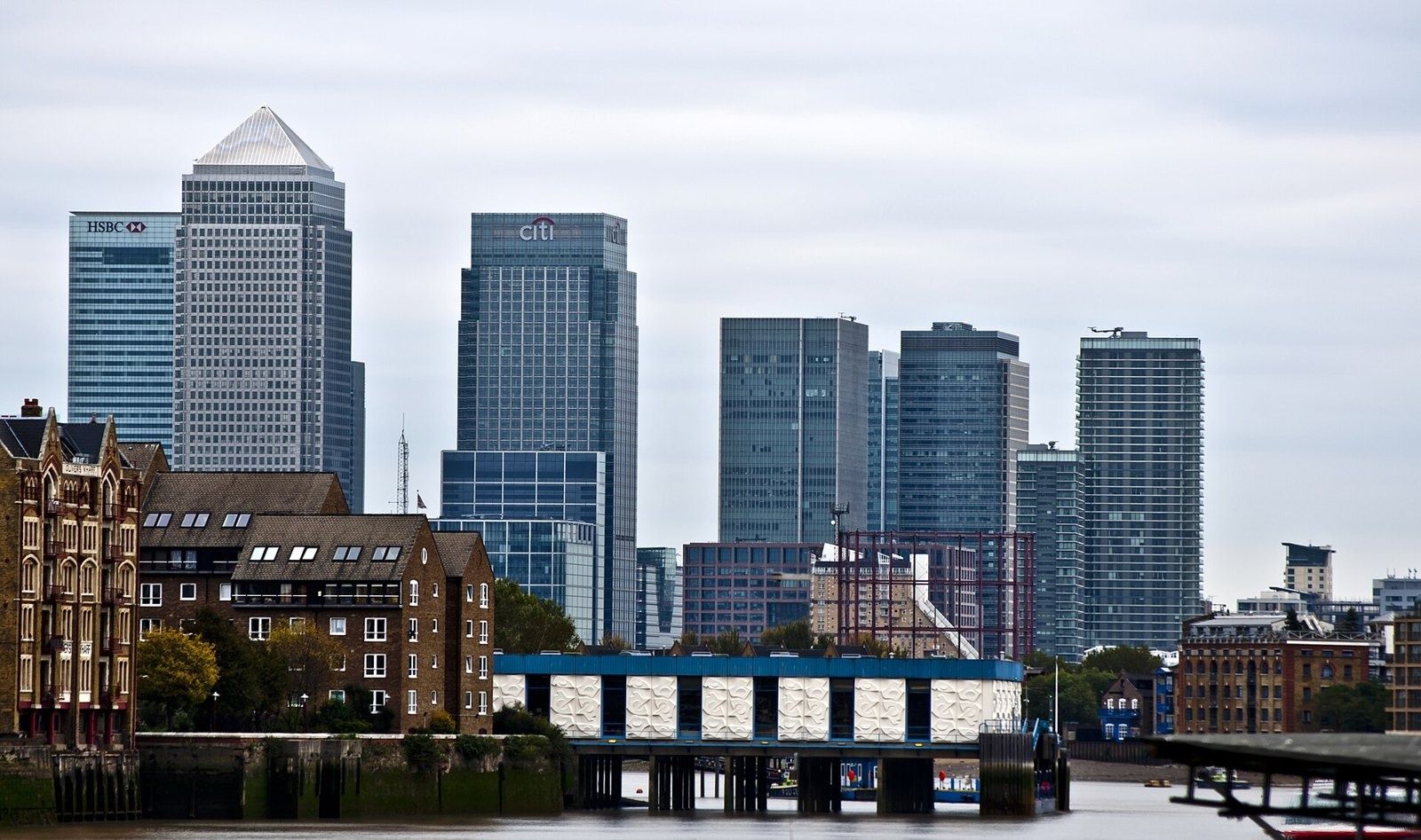 HSBC: Canary Wharf towers seen across the water behind older brick buildings