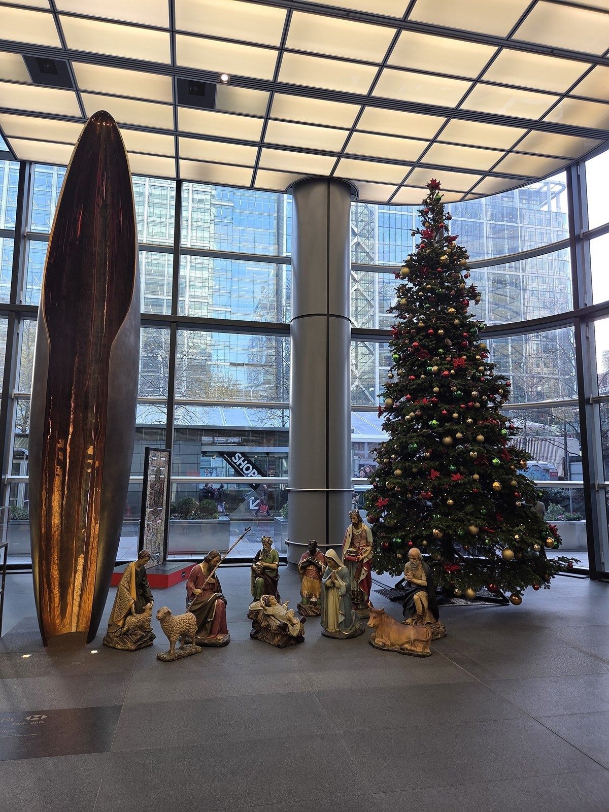 HSBC: Glass lobby with a tall bronze sculpture and a decorated Christmas tree