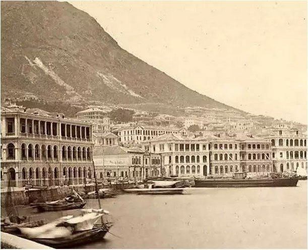 Sepia photo of colonnaded buildings along the Hong Kong waterfront