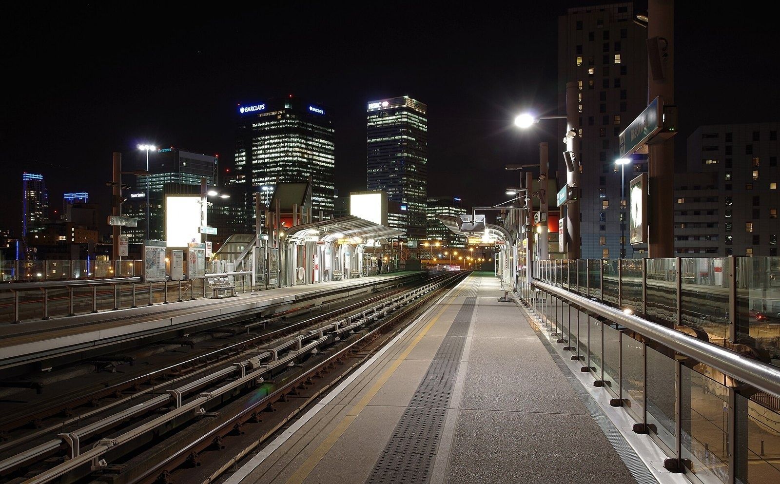 HSBC: Night view of towers beyond an empty railway platform
