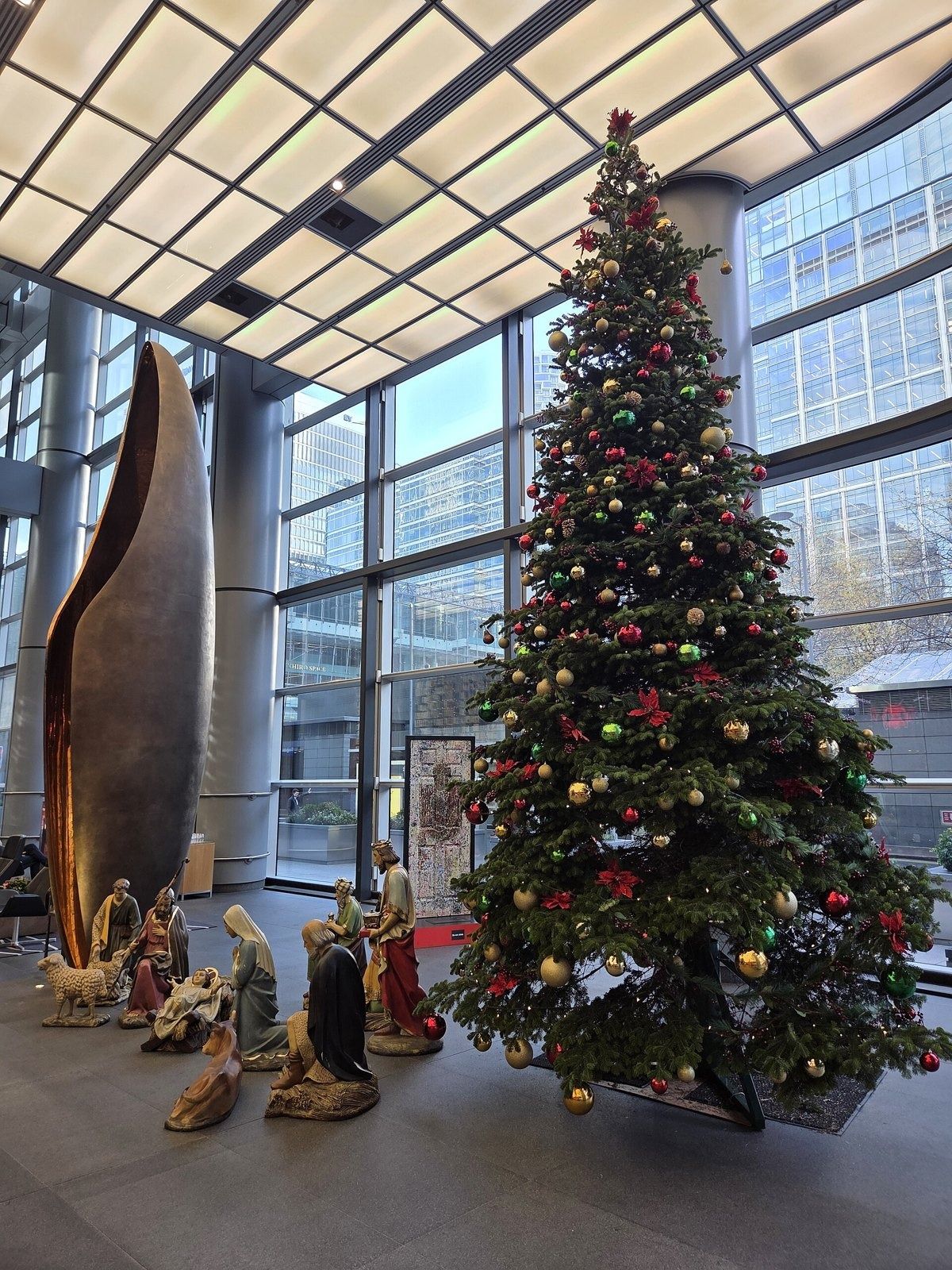 HSBC: Tall glass lobby with a large bronze sculpture, a Christmas tree and a nativity scene