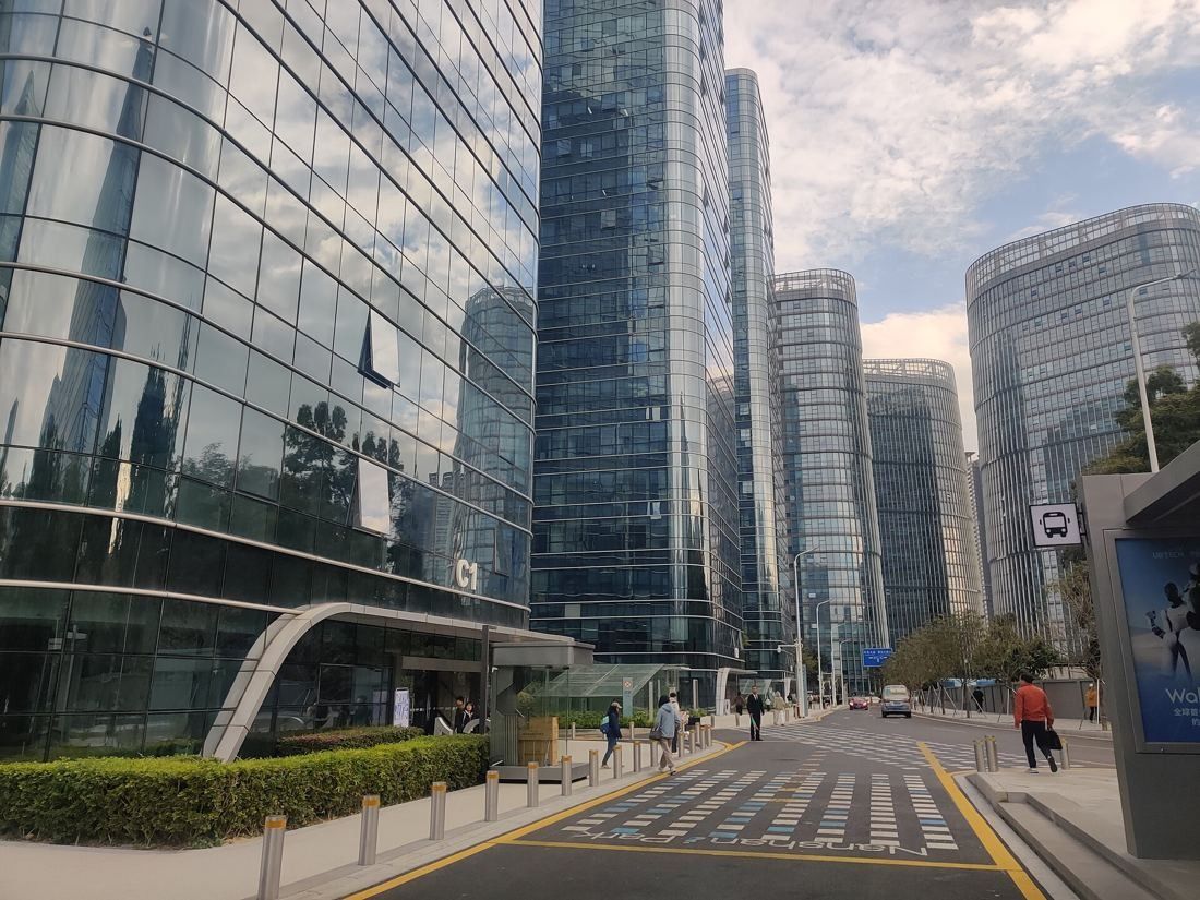 Glass office towers along a street with a covered walkway