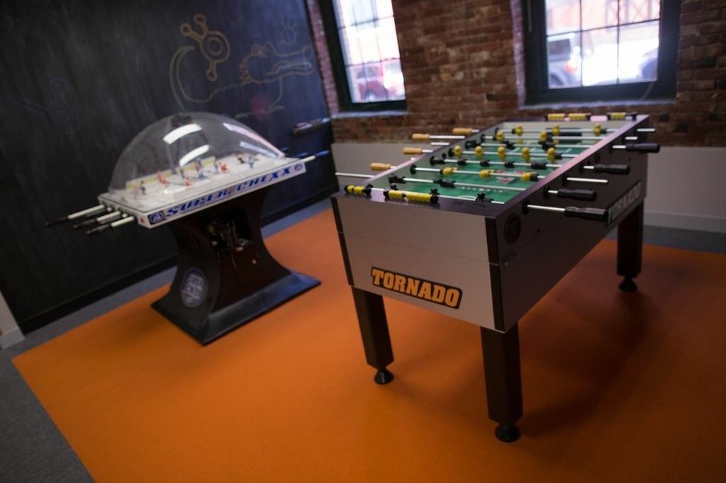 HubSpot: A foosball table and bubble hockey game on an orange floor