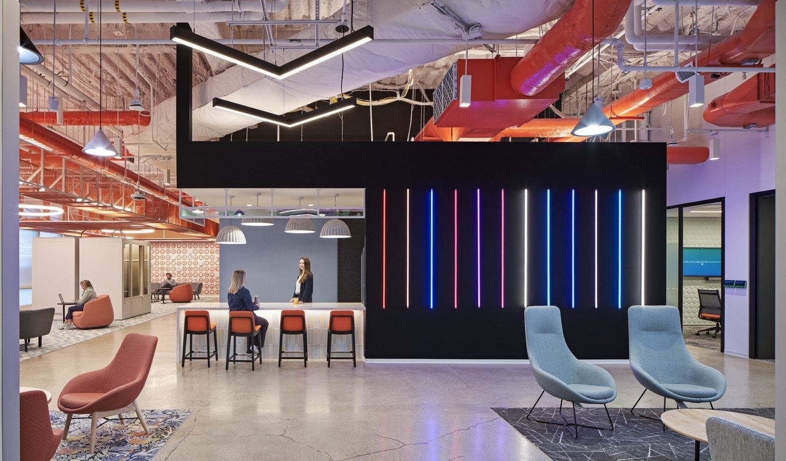 HubSpot: A reception lounge with neon light columns and blue chairs