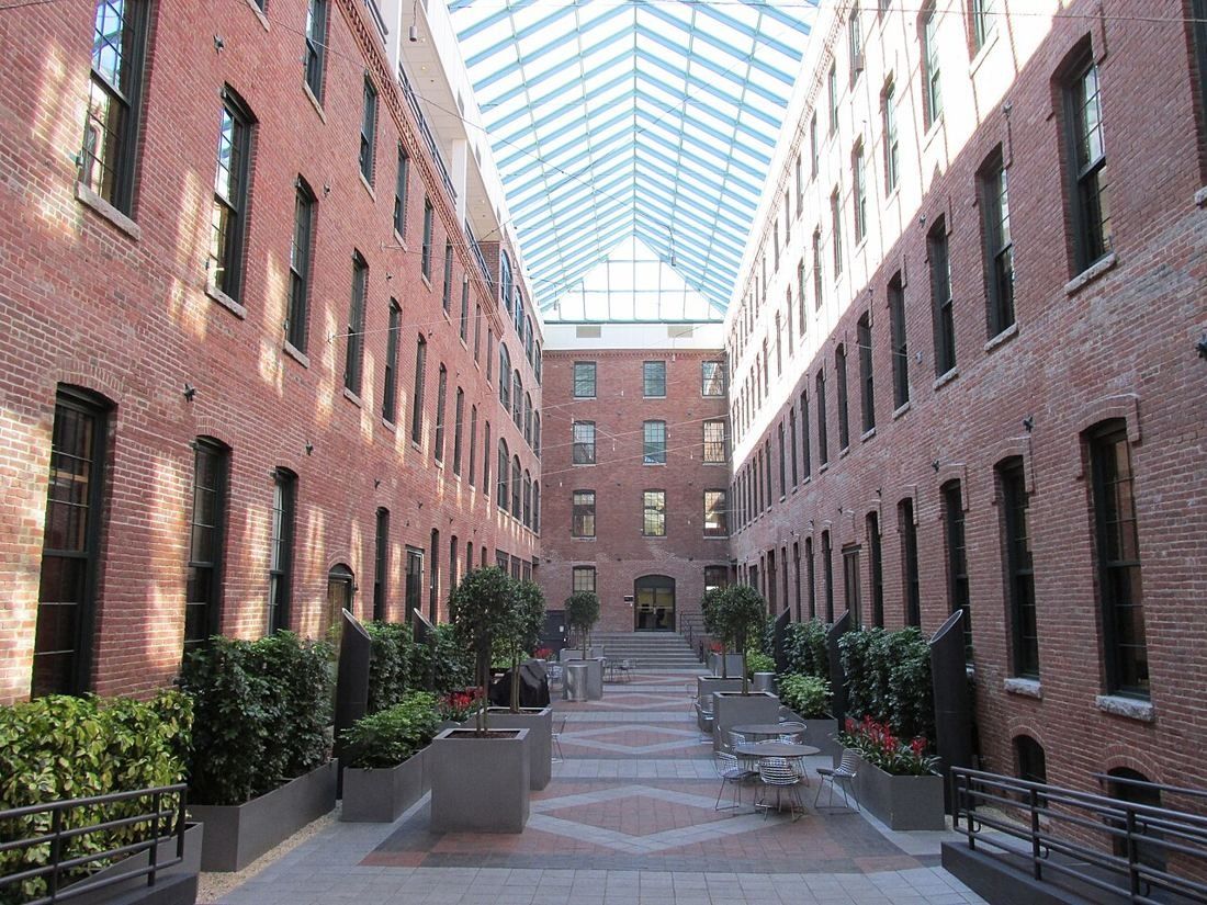 Glass-roofed atrium between old brick factory walls