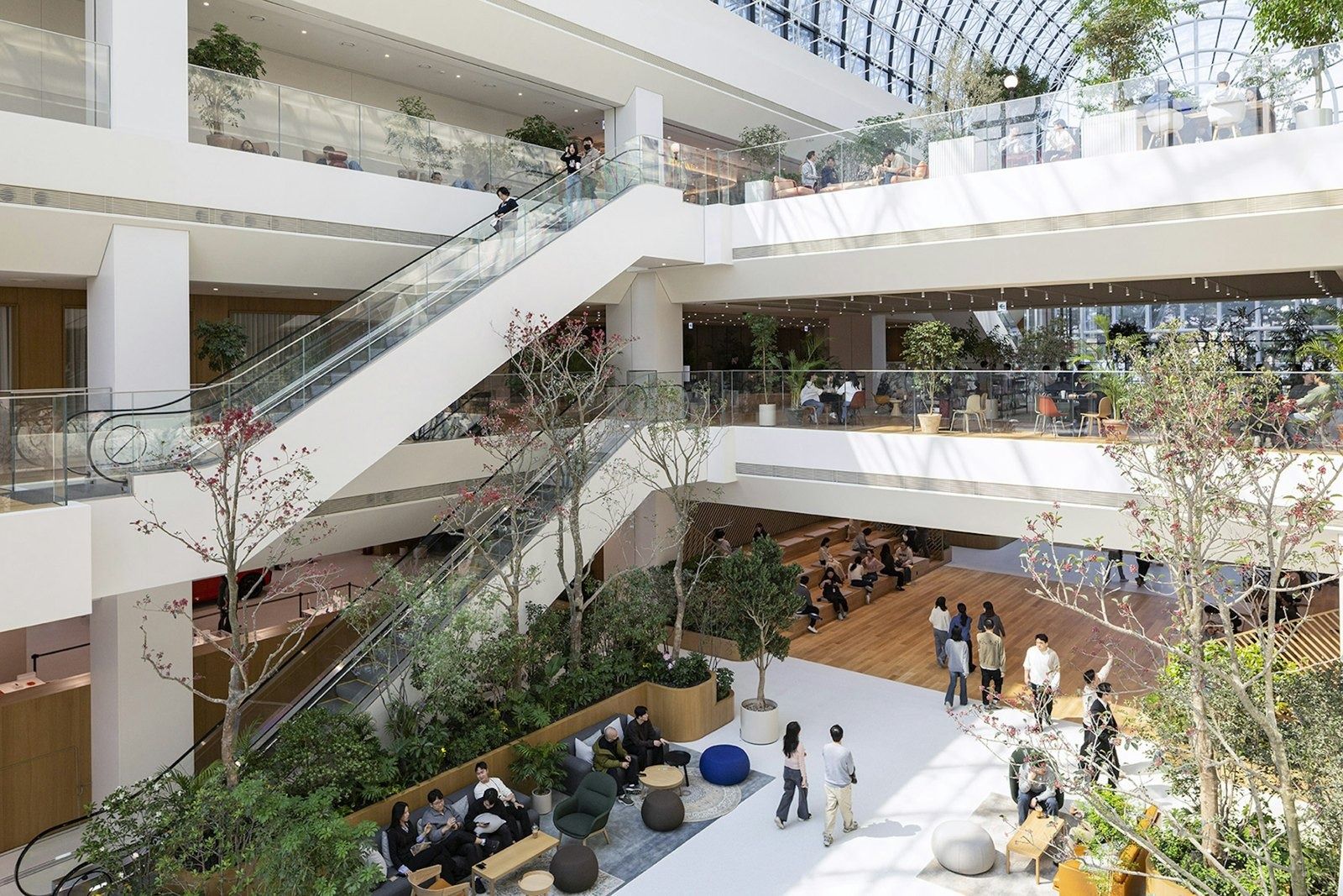 Multi-storey atrium with escalators, trees and floor seating