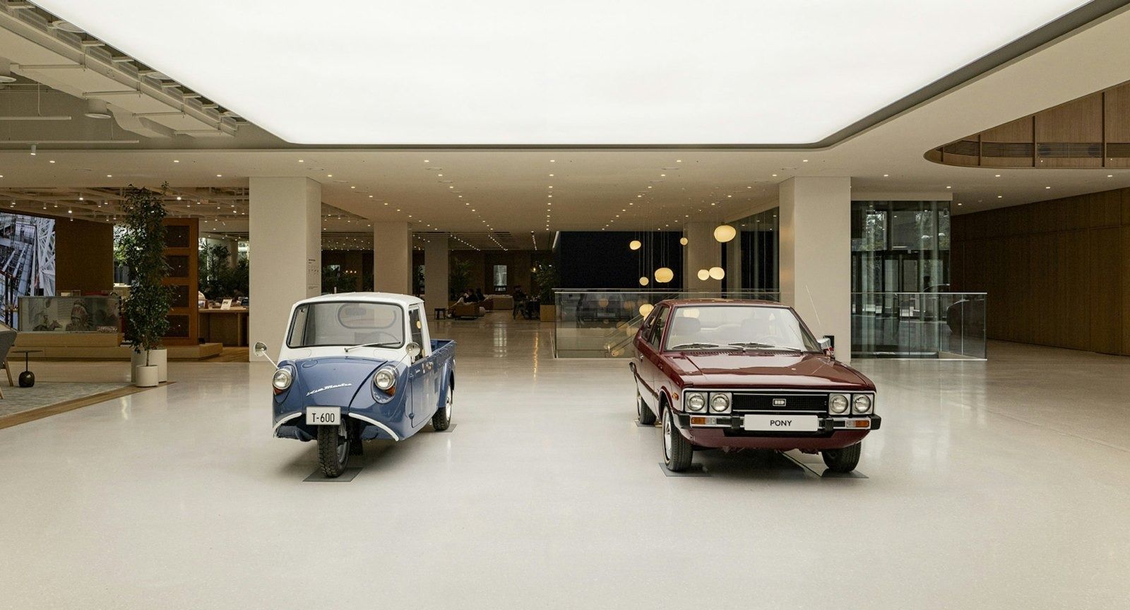 Hyundai Motor Company: Two classic Hyundai cars parked in a bright lobby