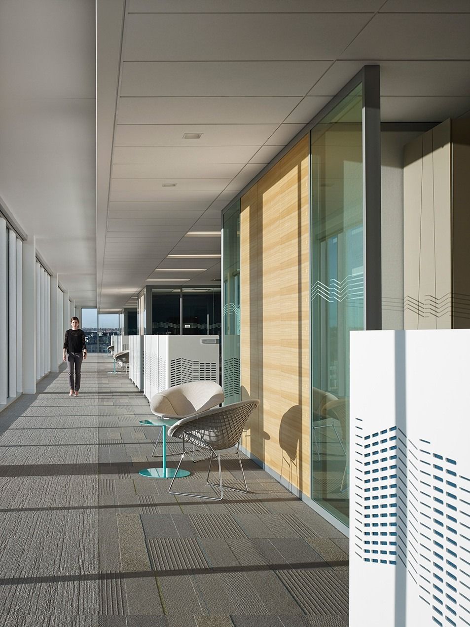 Imperial Oil: A long corridor lined with glass rooms and timber panels running into the distance