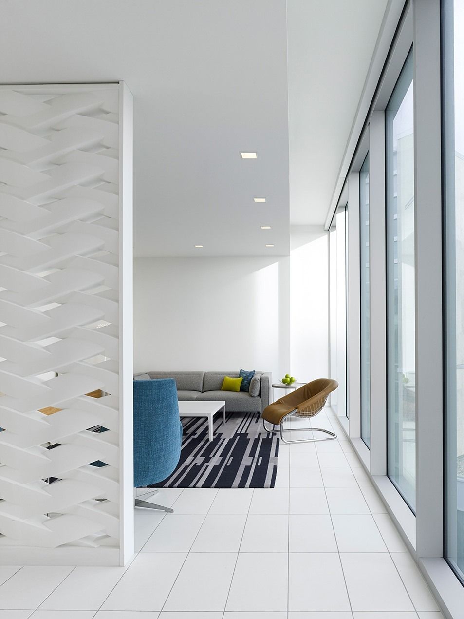 Imperial Oil: A white office edge with floor-to-ceiling windows and a seating nook behind a perforated screen
