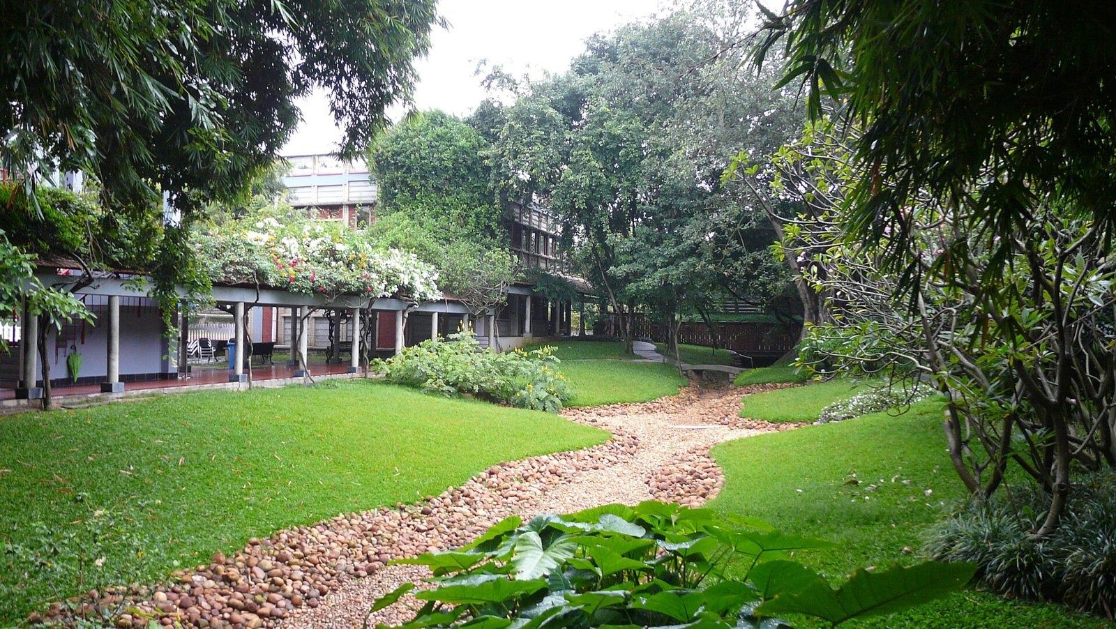 Infosys: Garden path through green lawns beside a covered walkway