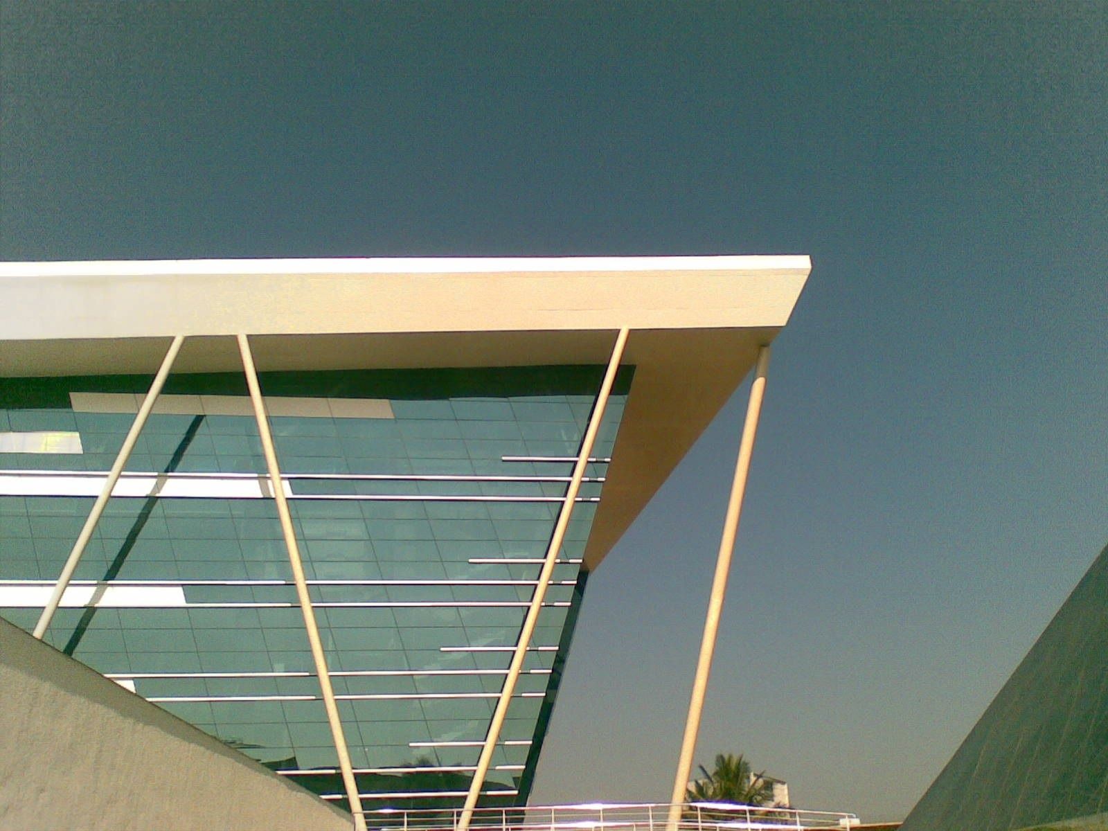 Infosys: Glass building with a cantilevered roof edge and slanted supports