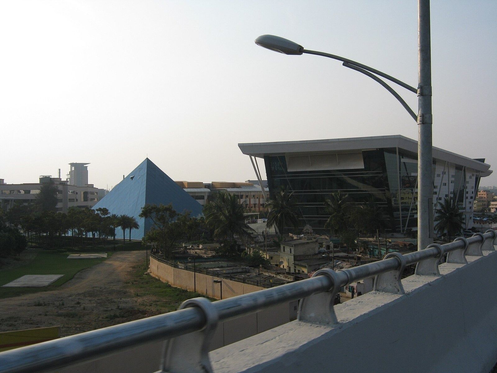 Infosys: Glass pyramid and a dark glass building seen across the campus from an elevated road