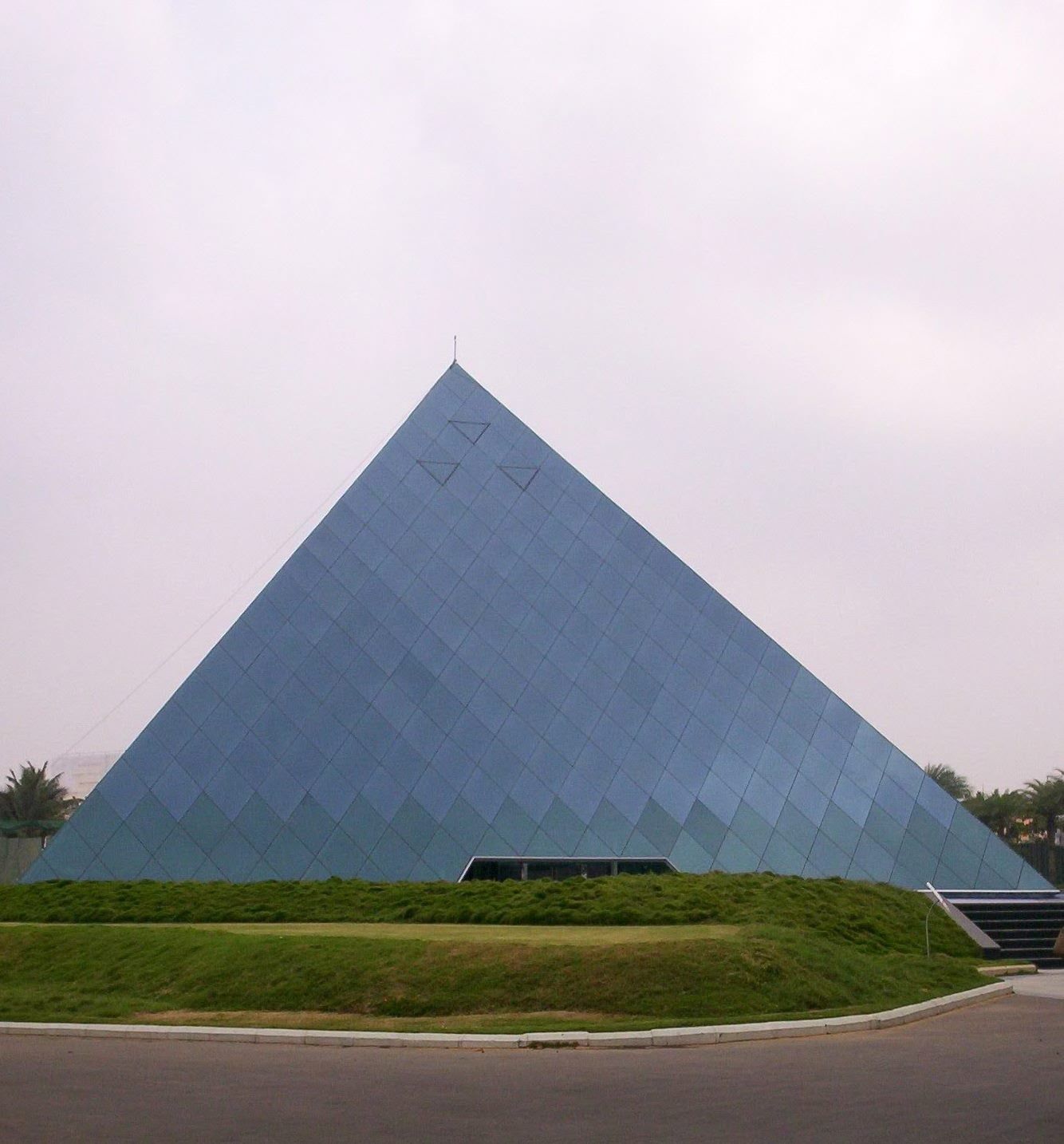 Infosys: Glass pyramid building on a lawn under a pale sky