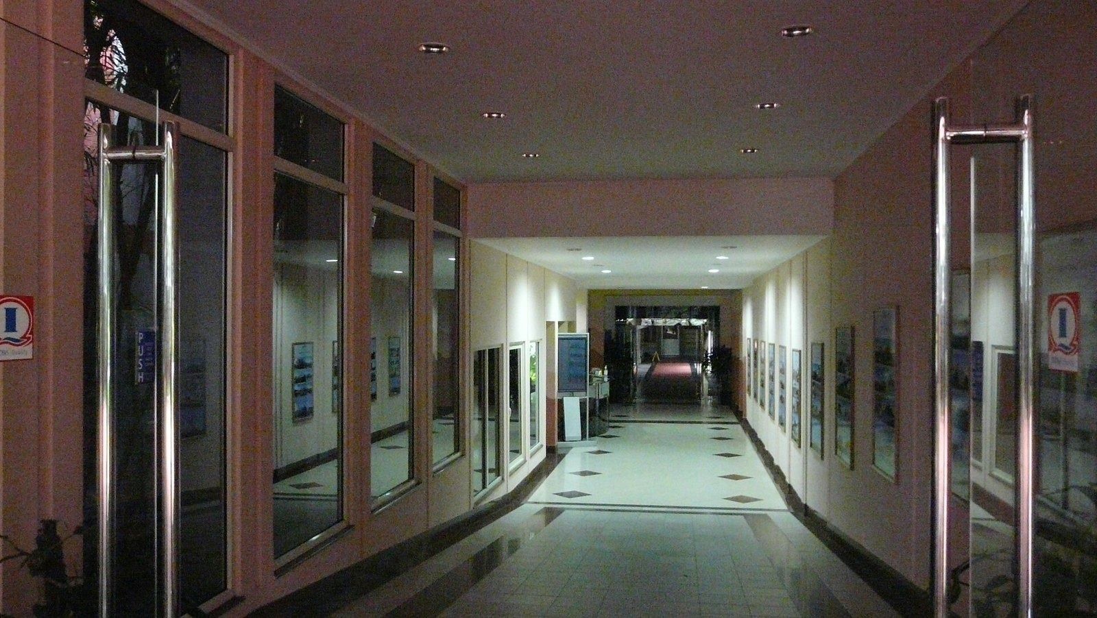 Infosys: Long corridor with glass doors and framed pictures on the walls