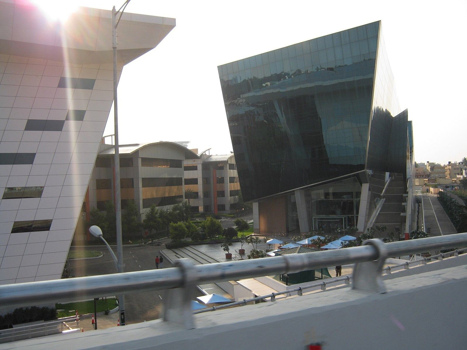 Infosys: Tilted dark glass building next to a white building with slanted windows