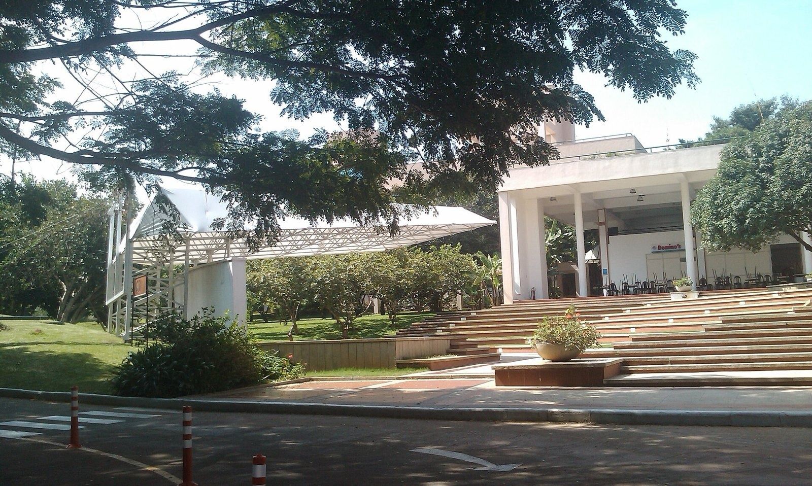 Infosys: White pavilion above stepped seating under large trees
