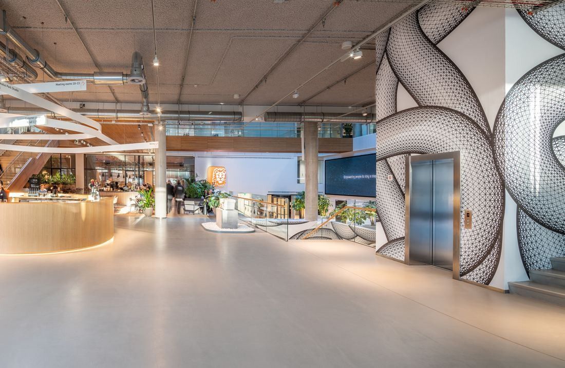 ING Group: Bright open ground floor with a large black-and-white graphic mural beside a lift