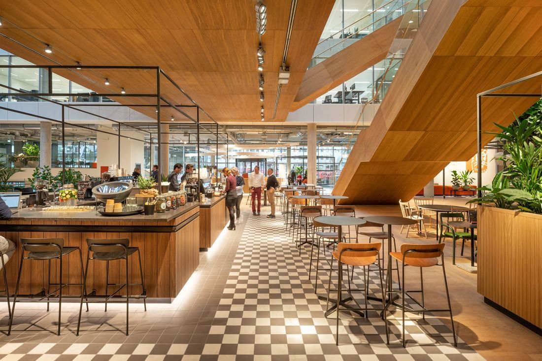 ING Group: Coffee bar with wooden counter, bar stools and checkerboard floor beneath wooden stairs