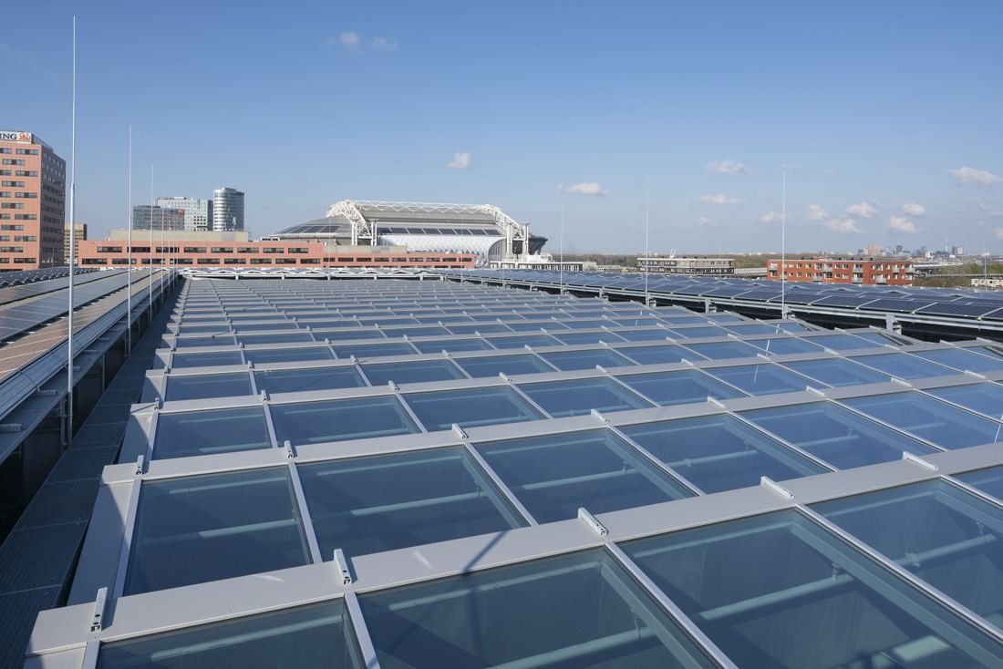 ING Group: Glass roof over an atrium with a stadium and city skyline in the distance