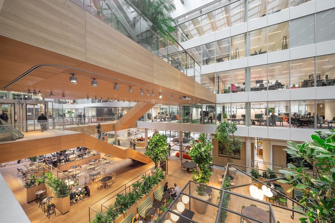 ING Group: Looking down into an atrium with wooden stairs, greenery and work areas below