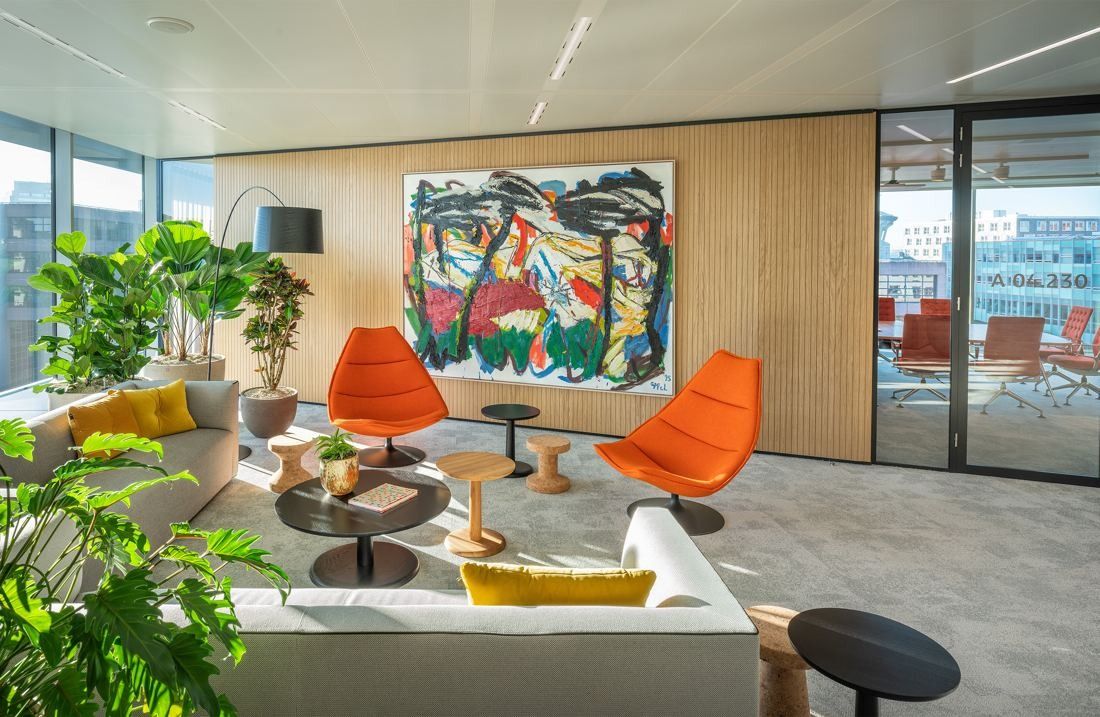 ING Group: Lounge with orange armchairs, a white sofa and a large colourful painting