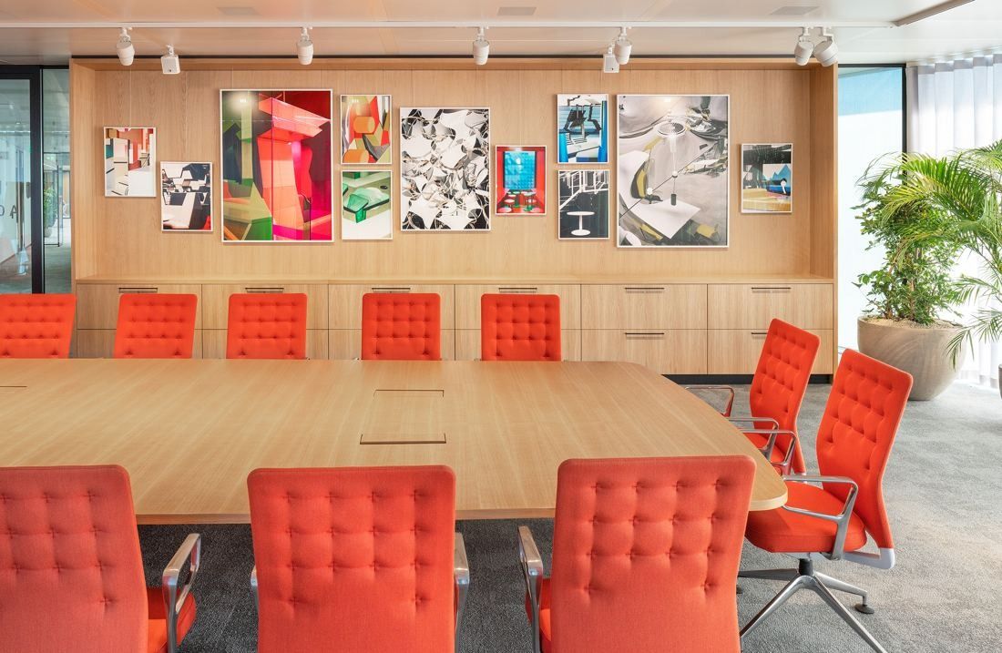 ING Group: Meeting room with a wooden table, orange chairs and a wall of framed artworks