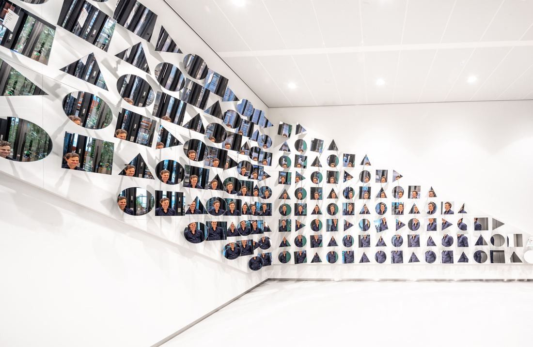 ING Group: White wall covered with a large installation of round mirrored and shaped elements