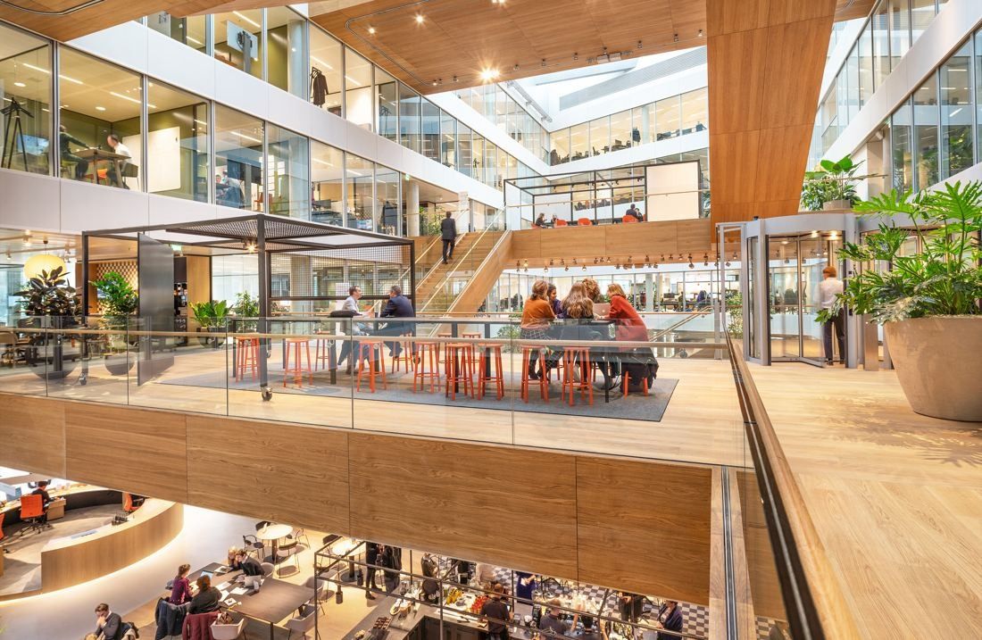 ING Group: Wooden platform with tables and plants overlooking a lower atrium floor