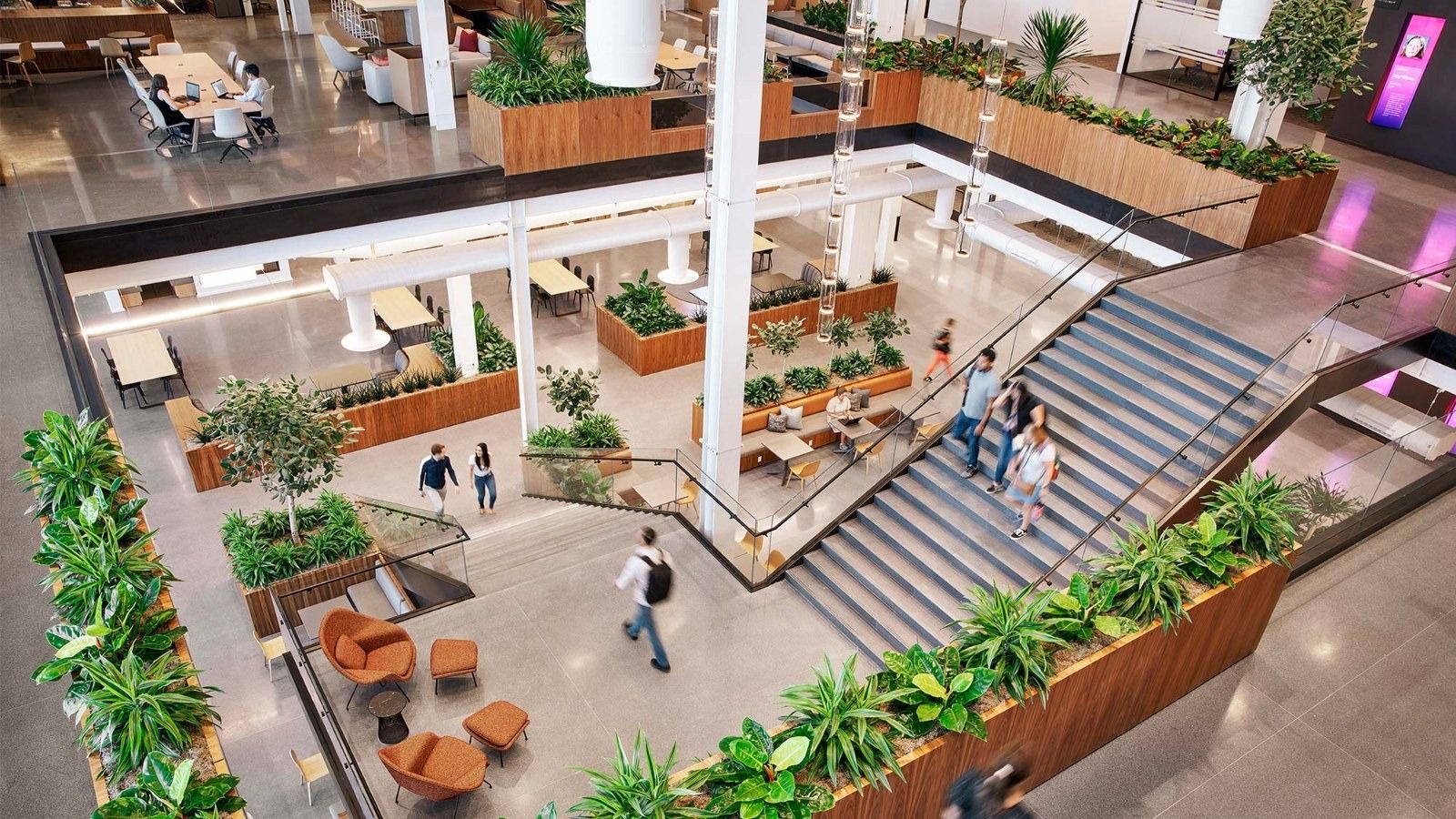 A wide stair with planters cascading through a bright multi-level atrium