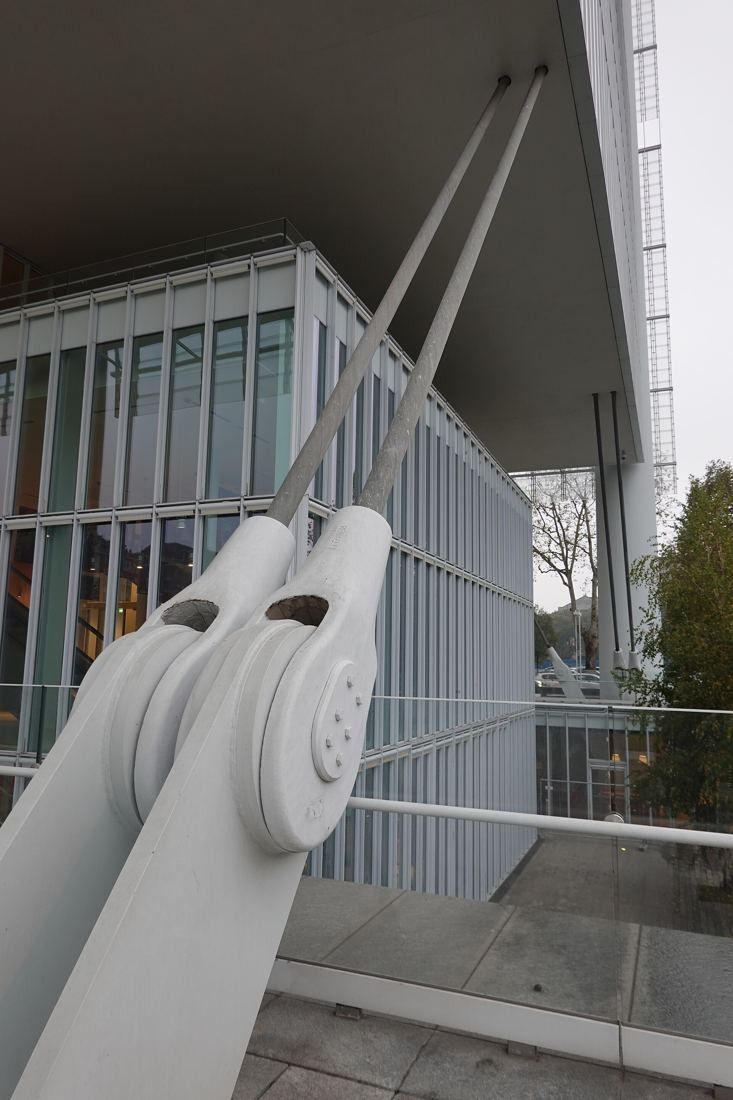 Intesa Sanpaolo: A white steel strut and pin joint supporting a canopy beside a glazed low building