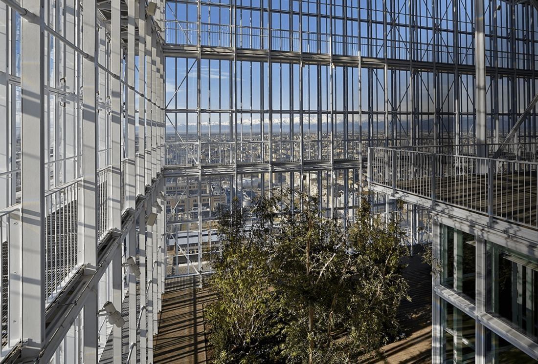 Intesa Sanpaolo: Olive-like trees among steel frames and glass walls, with the city beyond