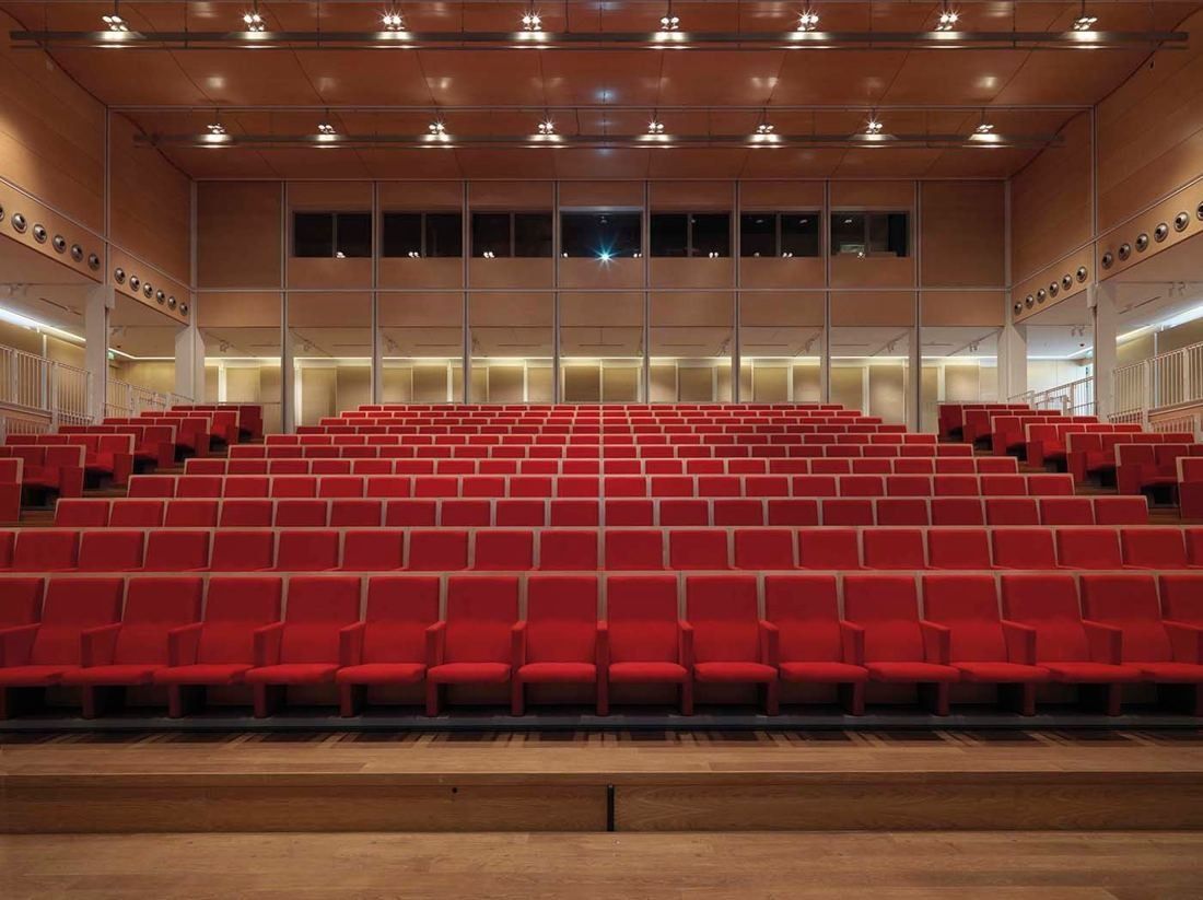 Intesa Sanpaolo: Rows of red seats facing the camera in a wood-panelled hall