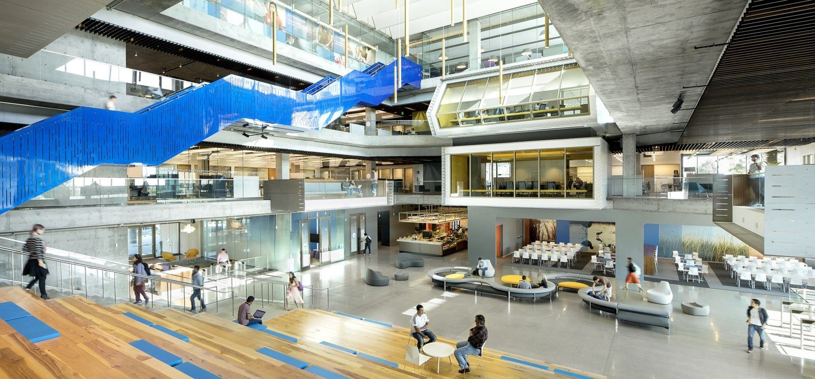 A tall atrium with a bright blue staircase at Intuit's Marine Way building
