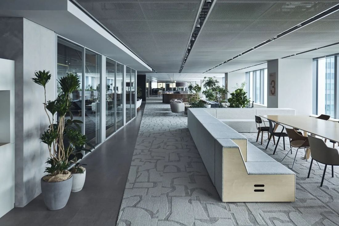 ITOKI: Long corridor-like floor with a bench, planters and work tables