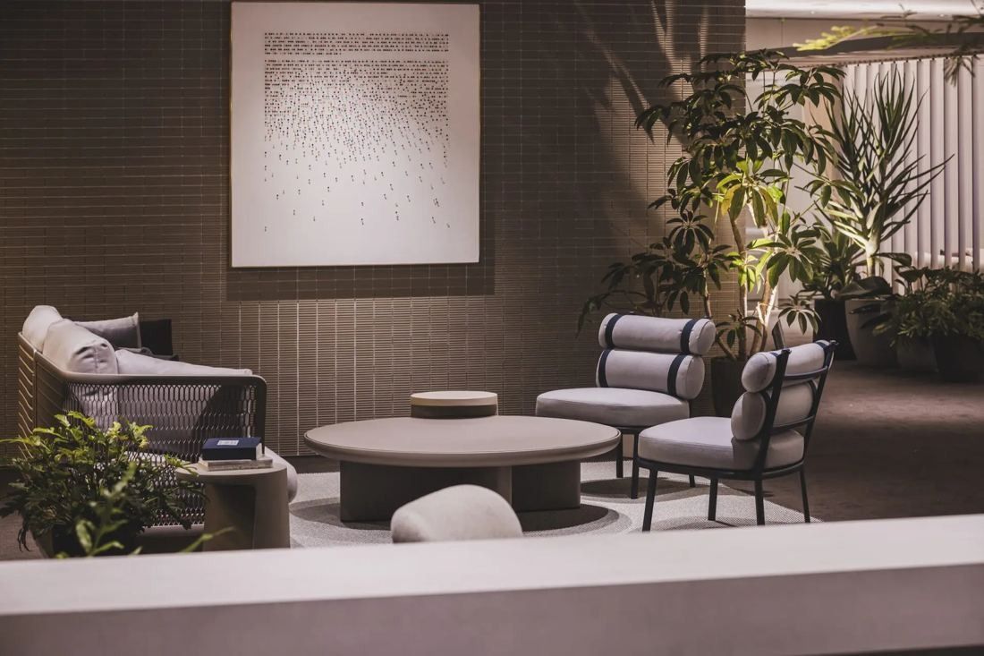 ITOKI: Lounge with armchairs, low table and plants beside a raised edge