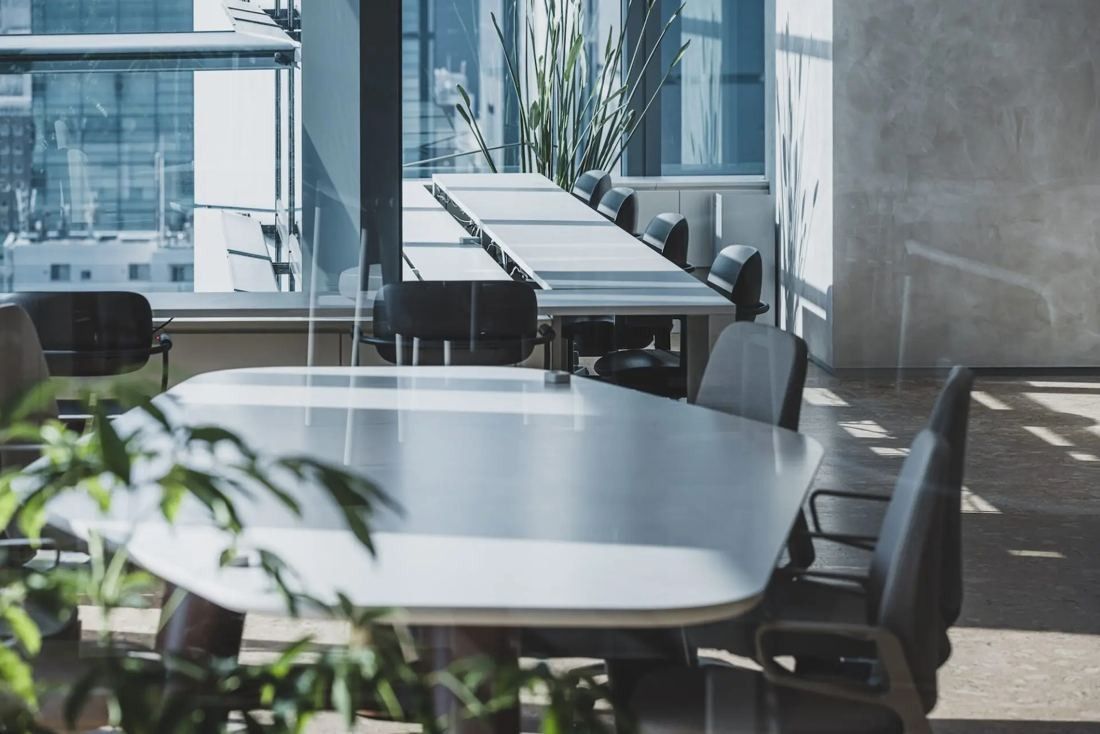 ITOKI: Rows of white meeting tables and chairs by tall windows