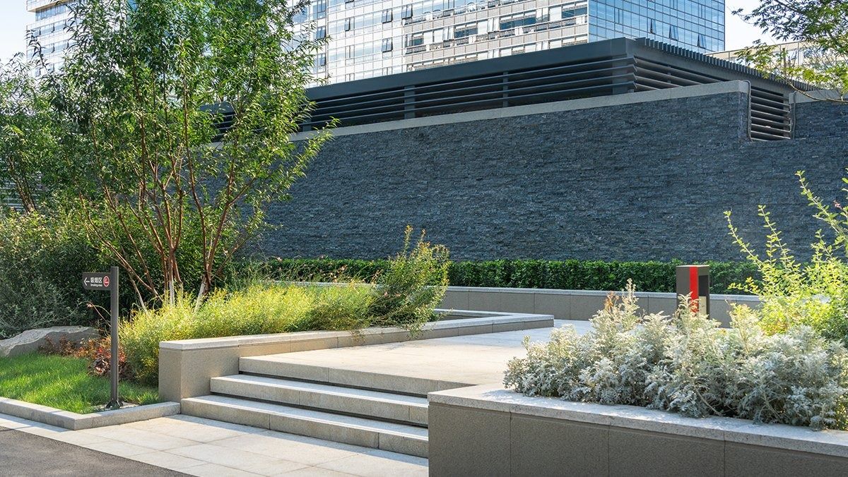 JD.com: Stone steps and planting in front of a dark stone wall