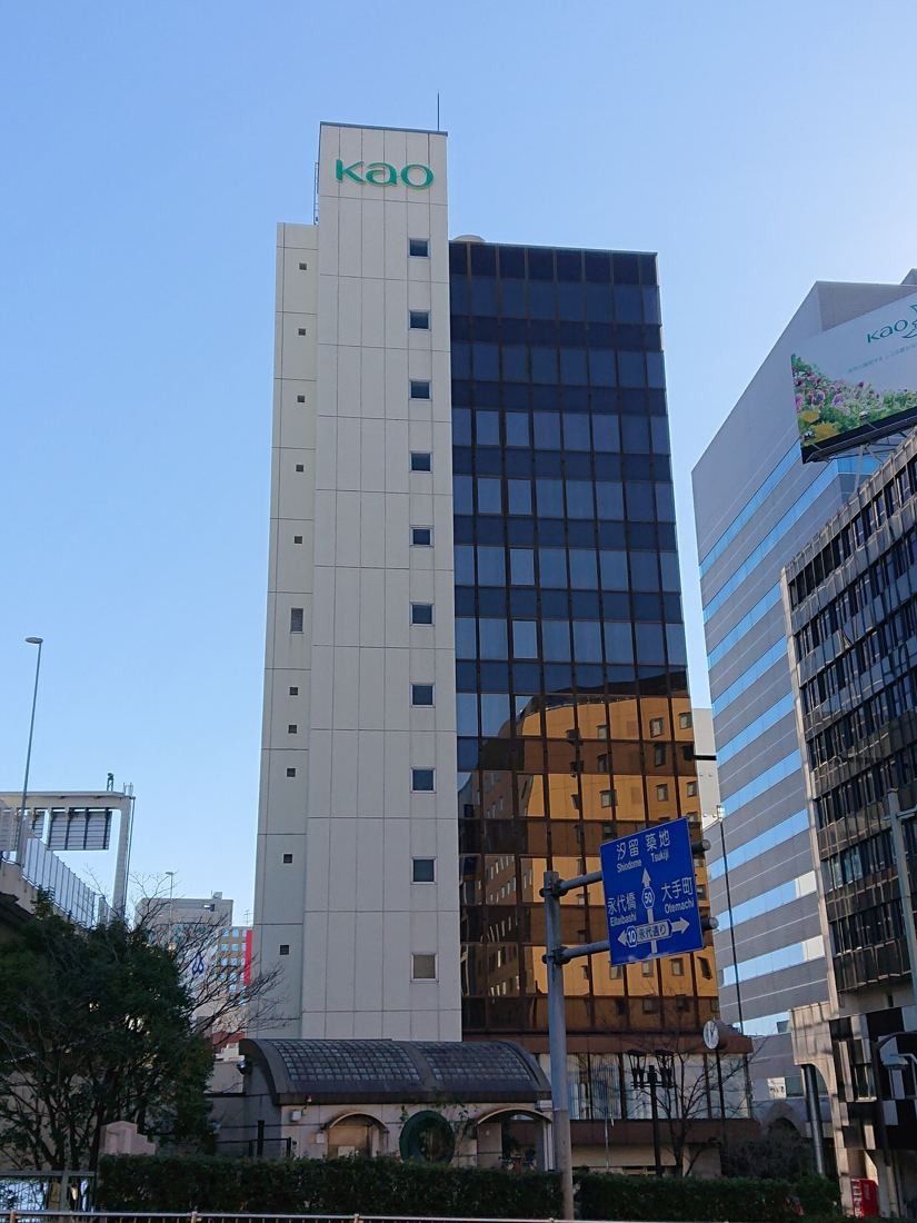 Kao: A slim white tower with a KAO sign and a dark glass section beside it