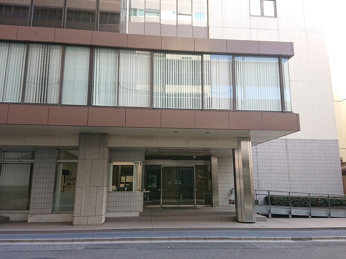 Kao: The ground floor of an office building with a canopy and glass entrance doors