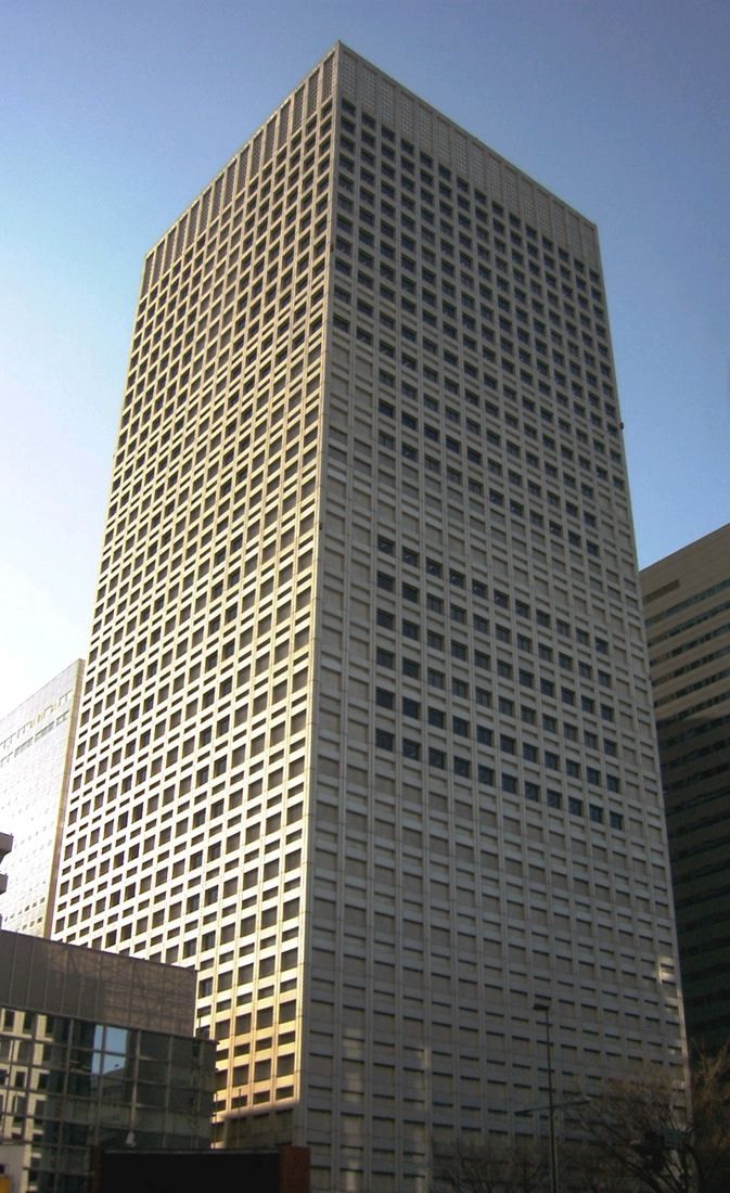 A tall pale skyscraper with a grid of small windows
