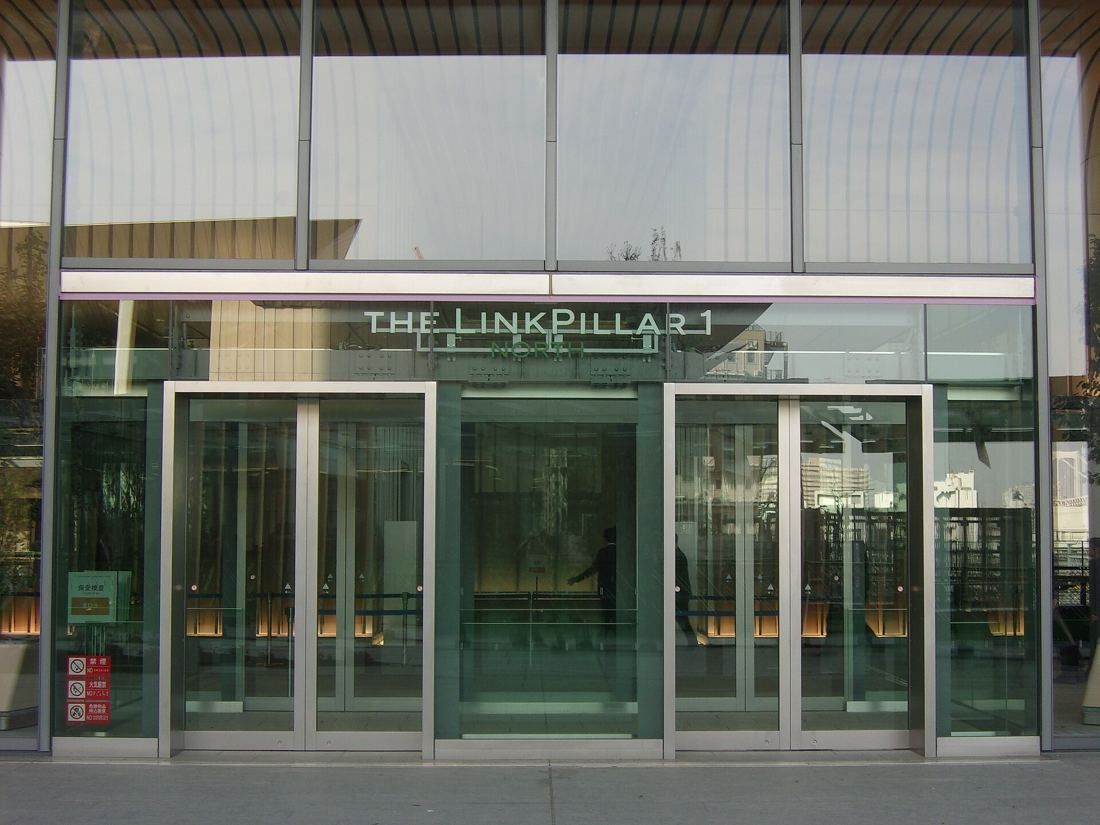 KDDI: Glass entrance doors under a sign reading THE LINKPILLAR 1