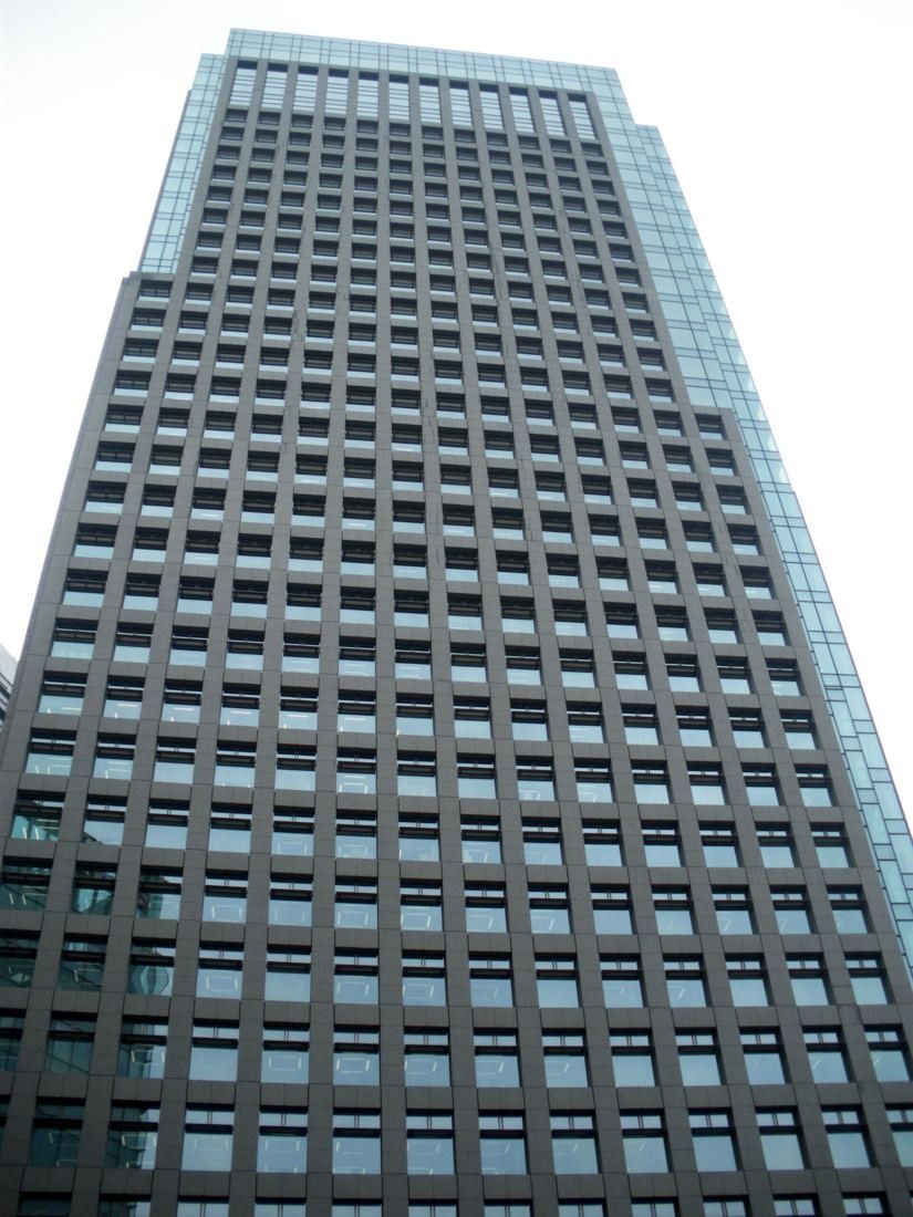 Looking up at a dark grid-facade office tower
