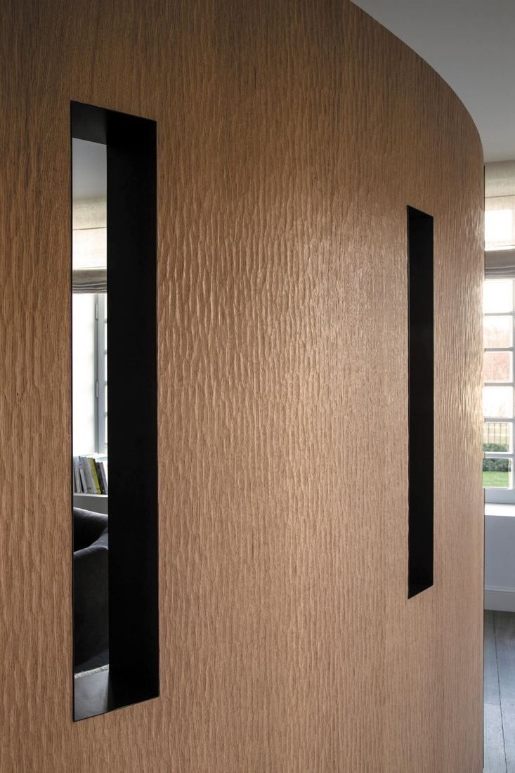 Kering: Curved oak-veneered wall with narrow vertical openings